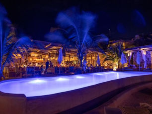 Piscina iluminada y ambiente nocturno en Tantra Beach Club Tulum